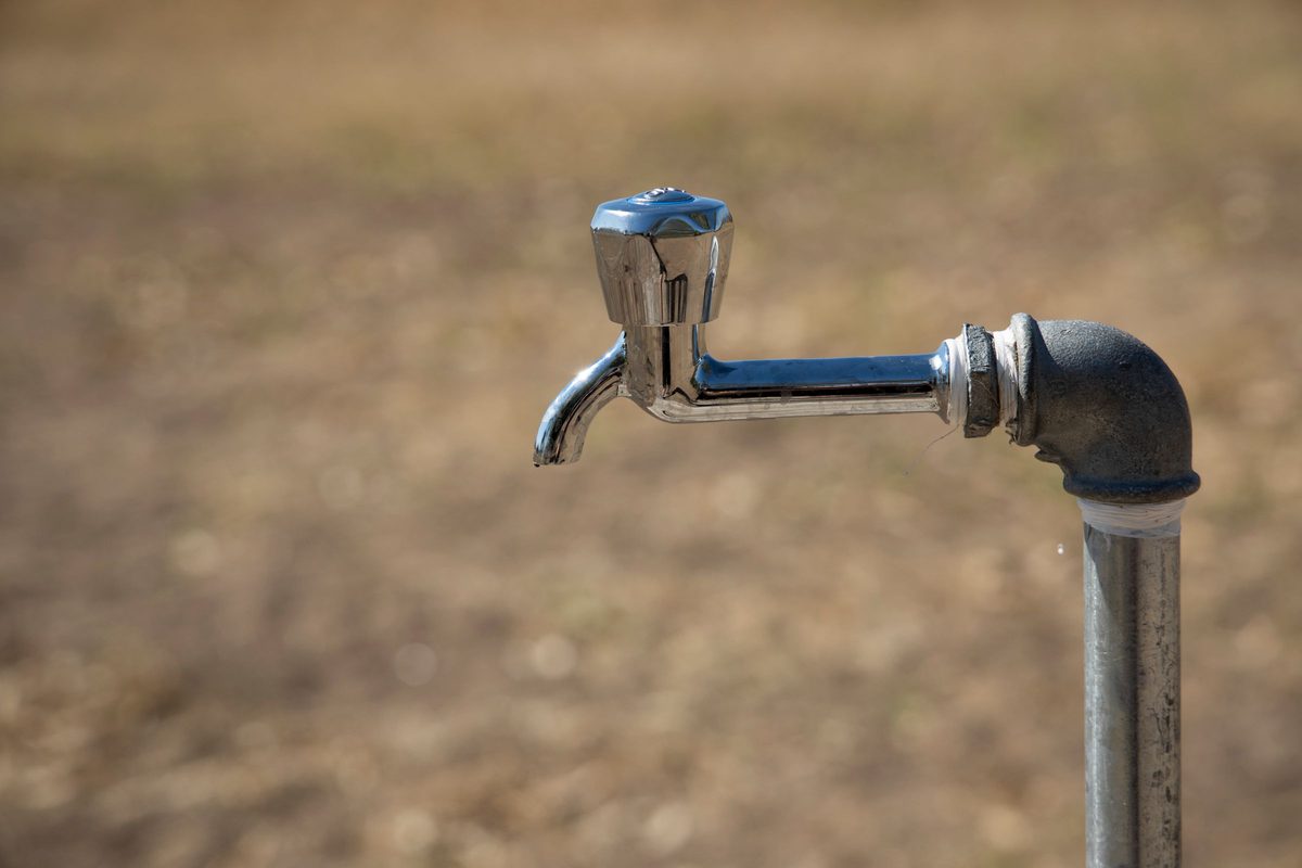 Outdoor faucet on a metal standpipe above dry ground